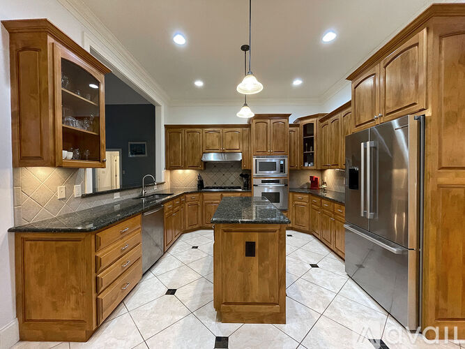 A kitchen with wooden cabinets and a black granite countertop.