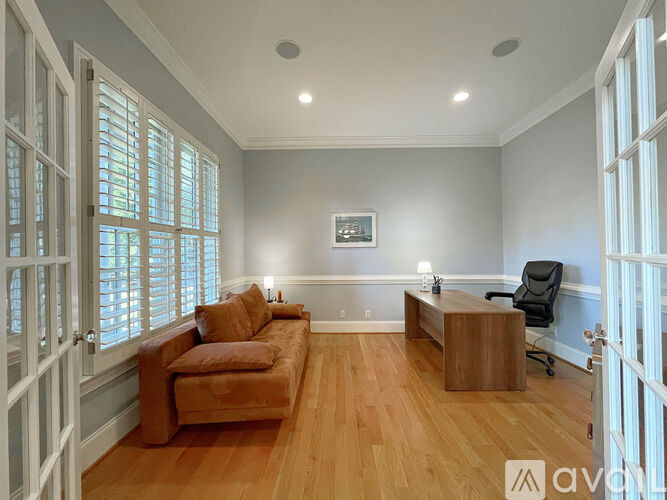 A living room with a brown couch and a wooden coffee table.
