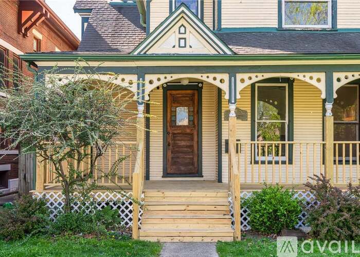 A house with a green front porch and a wooden door.