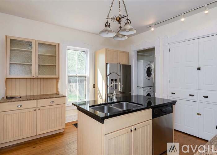 A kitchen with wooden cabinets and a black countertop.