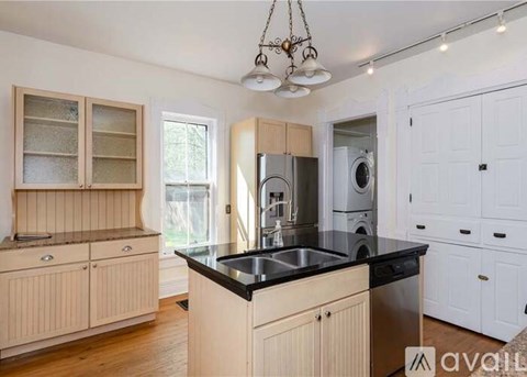A kitchen with wooden cabinets and a black countertop.