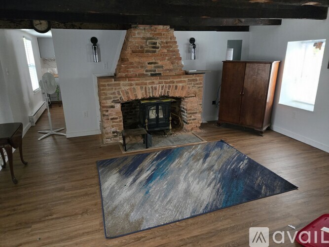 A room with a fireplace and a rug on the floor.