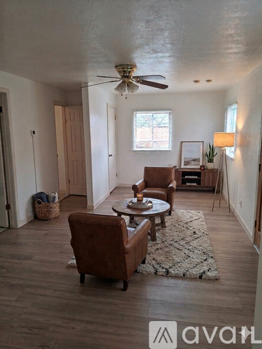 A living room with a brown leather chair and a white rug.