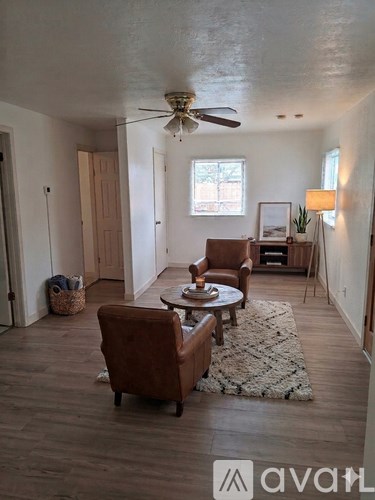 A living room with a brown leather chair and a white rug.