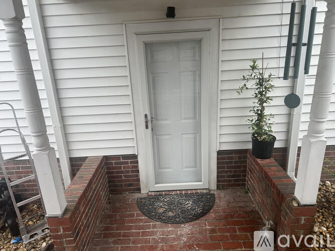 A white door is on the left of a white house.