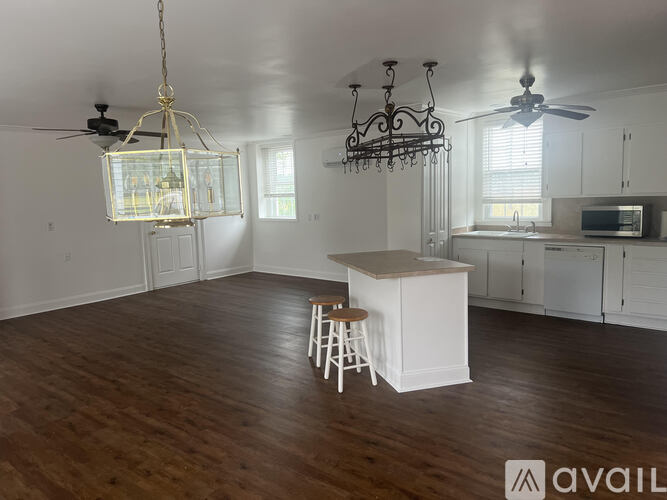 A kitchen with a white island and a bar stool.