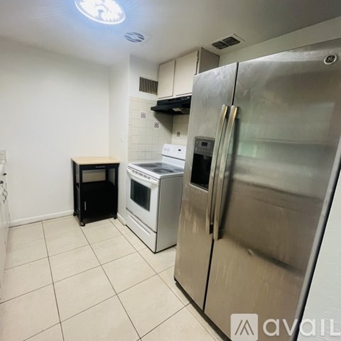 A kitchen with a stainless steel refrigerator and a white oven.