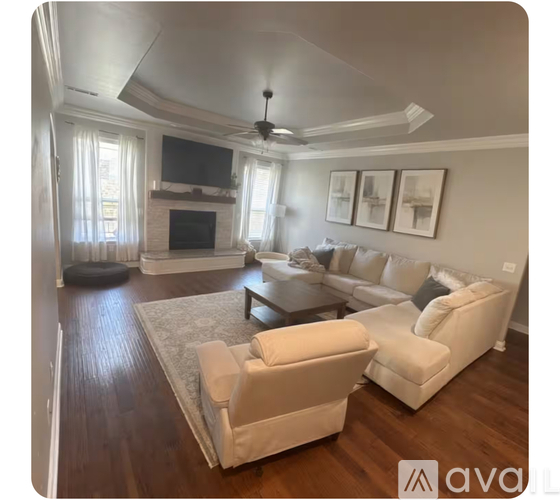 A living room with a white couch and a television.