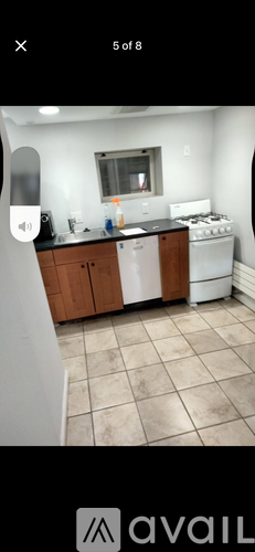 A kitchen with a white stove and wooden cabinets.