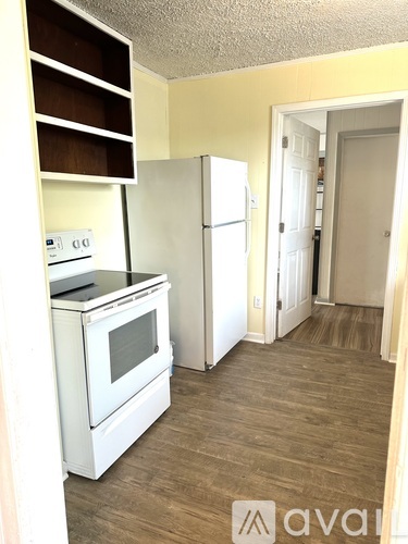 A kitchen with a white oven and a white refrigerator.