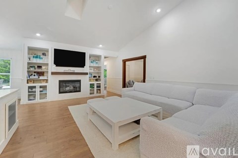 A modern living room with a white sofa and a fireplace.