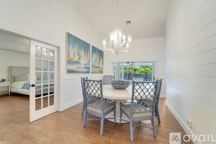 A dining room with a white table and chairs.