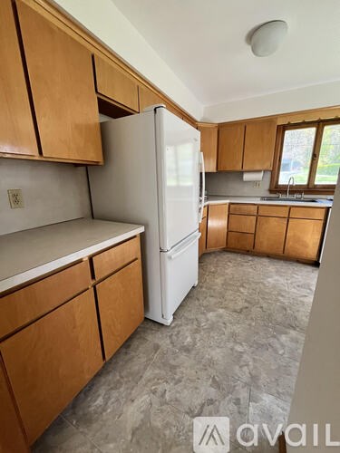 A kitchen with wooden cabinets and a white refrigerator.