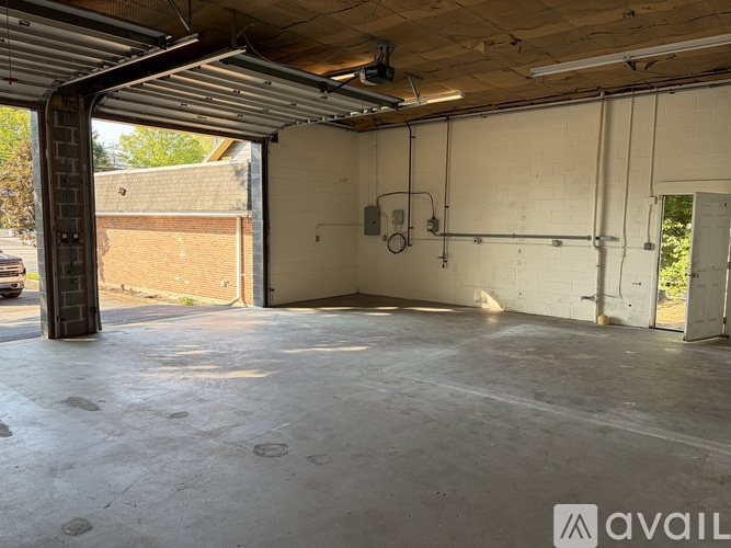 A large, empty garage with a concrete floor and a metal roof.