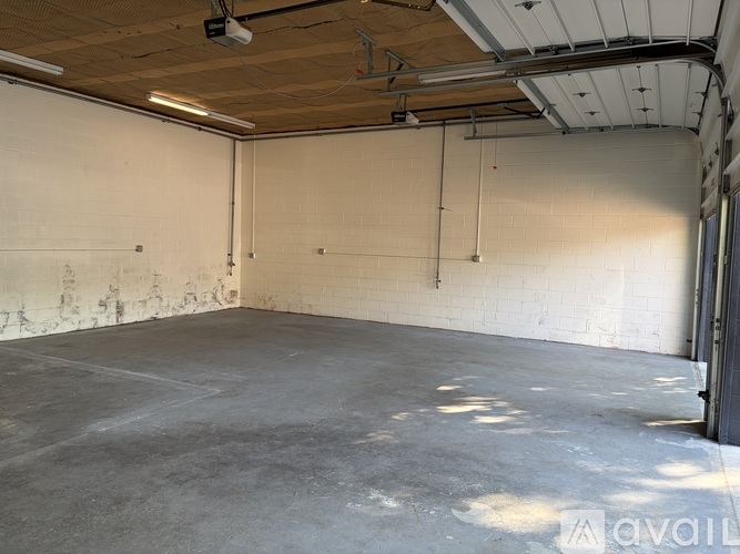 A large, empty room with a concrete floor and white walls.