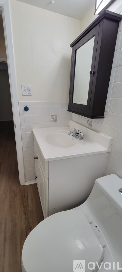 A white sink with a black cabinet above it.