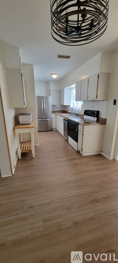 A kitchen with wooden floors and white walls.