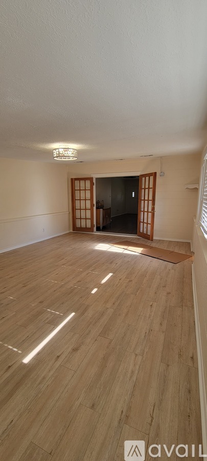 A room with wooden flooring and a sliding door.