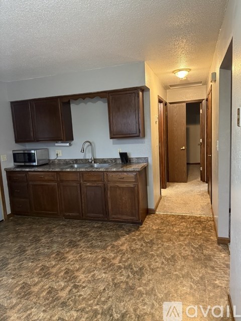 A kitchen with brown cabinets and a granite countertop.
