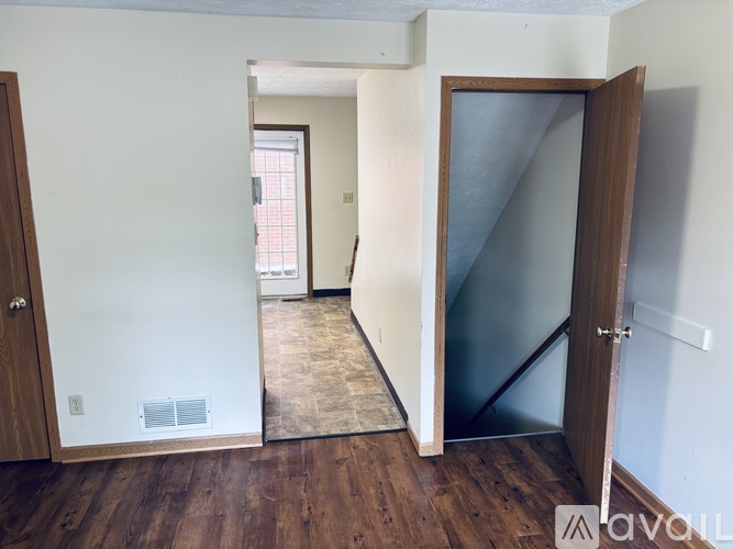 A room with a wooden floor and a mirror on the wall.