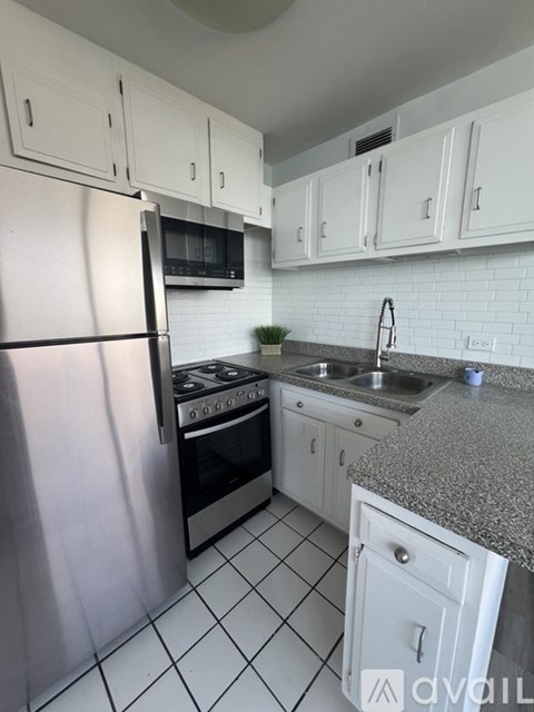 A kitchen with white cabinets and a granite countertop.