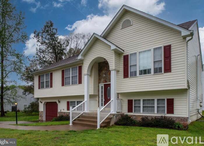 A two-story house with a red door and red shutters.