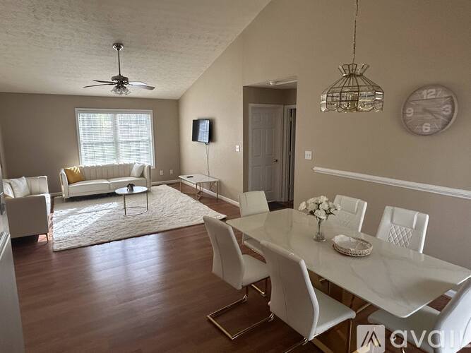 A dining room with a white table and chairs.