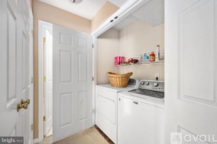 A small kitchen with a white oven and a white door.