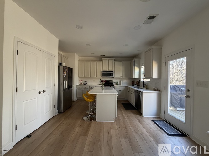 A kitchen with white cabinets and a white island in the middle.