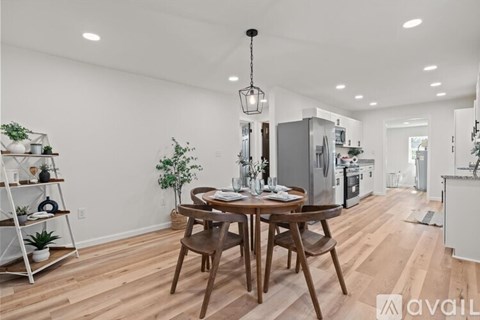 A modern kitchen with a wooden dining table and chairs.