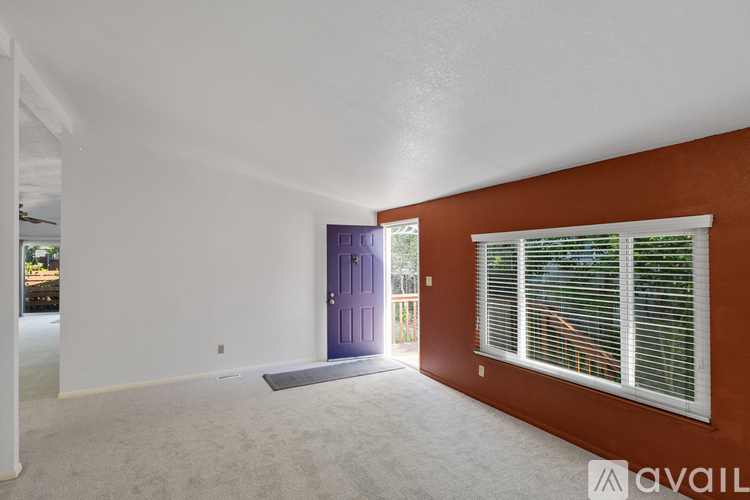 A room with a purple door and a window with blinds.