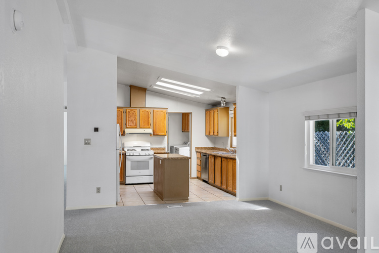 A kitchen with wooden cabinets and a white stove top oven.