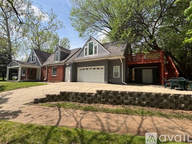 A house with a red garage door and a stone wall in front.