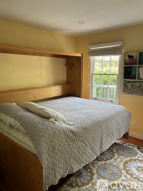 A bedroom with a bed and a window.