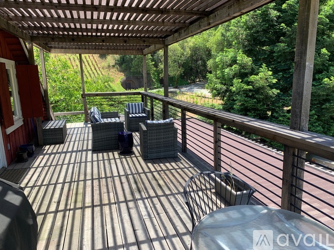 A wooden deck with a table and chairs overlooking a wooded area.