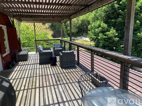 A wooden deck with a table and chairs overlooking a wooded area.