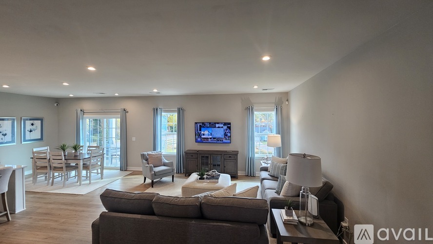 A living room with a couch, chairs, and a television.