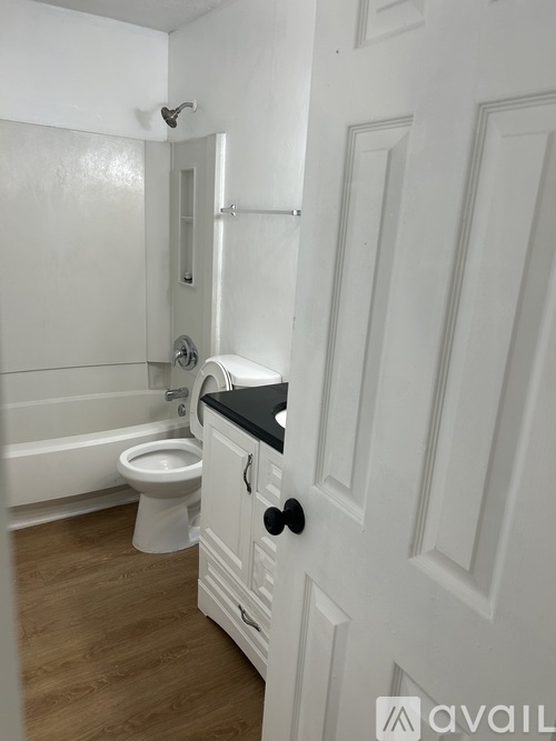 A white bathroom with a toilet and a shower.