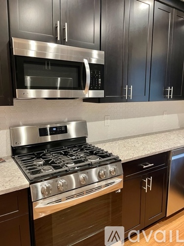 A modern kitchen with a stainless steel stove and microwave.