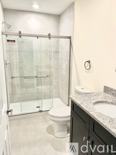 A bathroom with a toilet, sink, and walk-in shower.