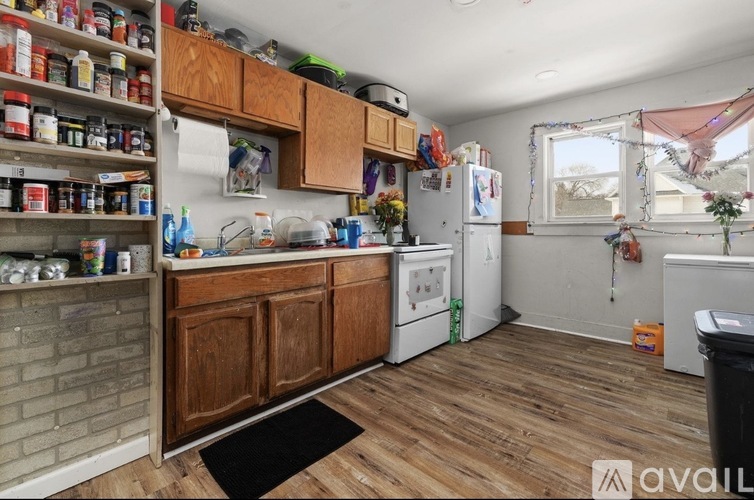 A kitchen with wooden cabinets and a brick wall.