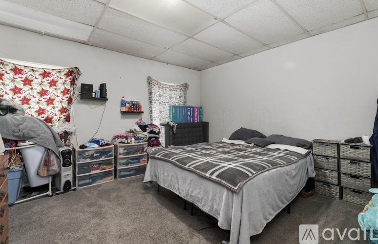 A bedroom with a bed, a desk, and a chair.