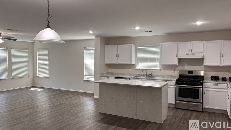 A modern kitchen with white cabinets and stainless steel appliances.