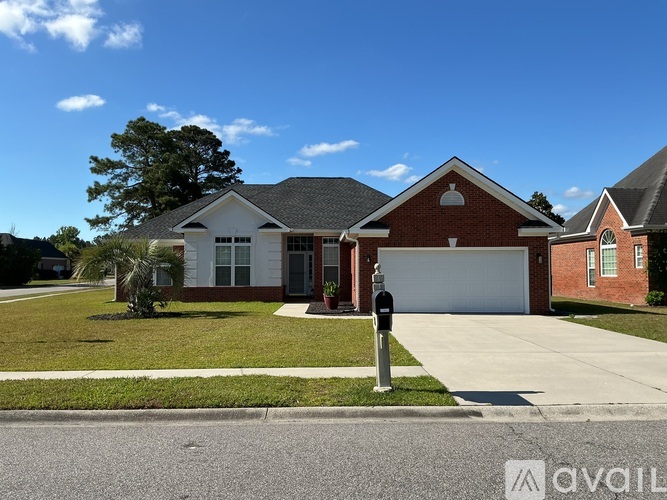 A house with a red brick exterior and a white garage door is for sale.