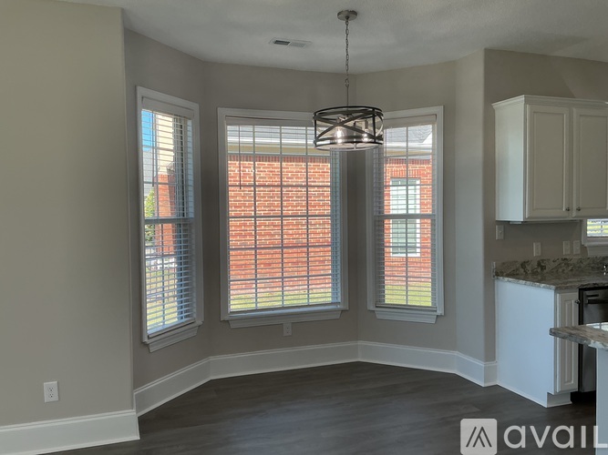 A kitchen area with a window and a hanging light fixture.
