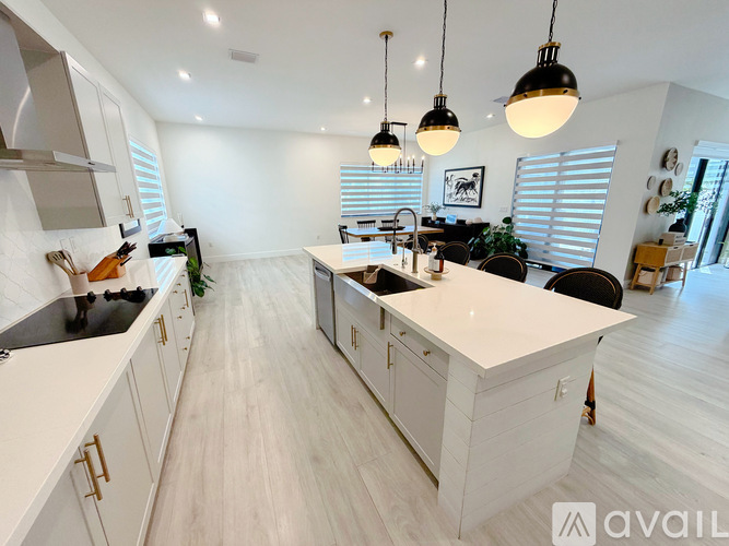 A modern kitchen with white cabinets and a large island.