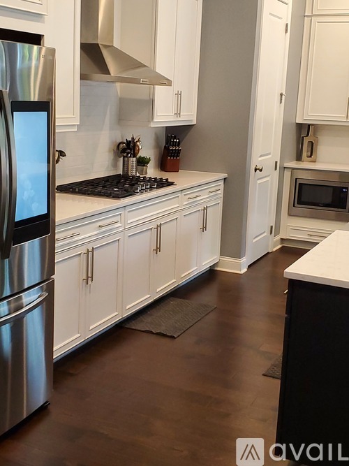 A kitchen with white cabinets and a black stove top.