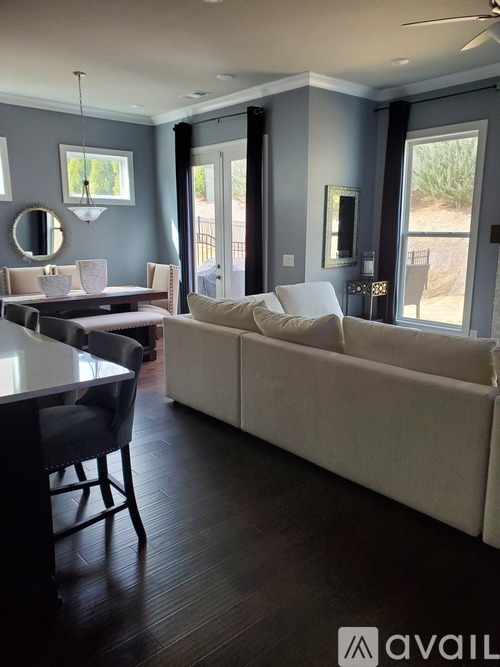 A modern living room with a white sofa and a black dining table.