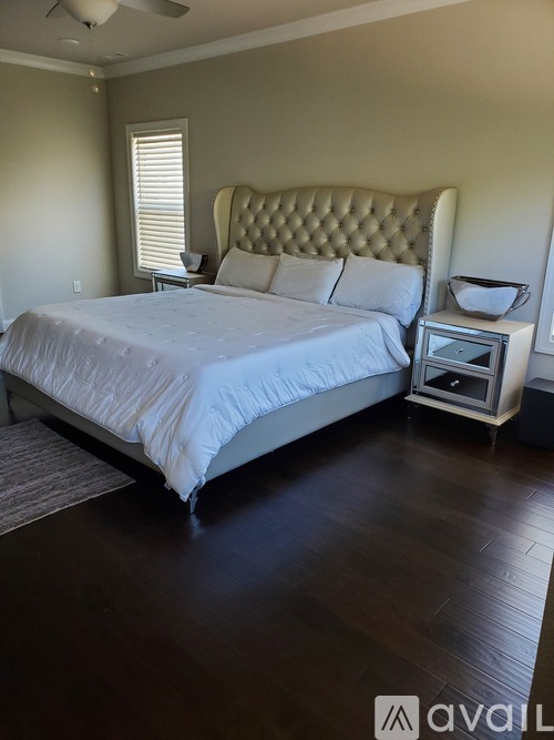 A bedroom with a large bed and a small table with a bowl on it.