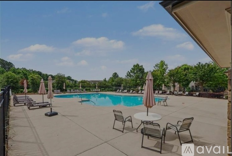 A pool area with chairs and umbrellas is available for use.